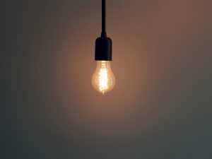 A light bulb and a dark background, the light is on.