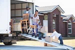 A young man and a young woman in their apartment, holding a big box together