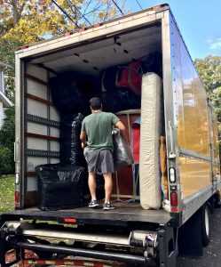A man standing in a big moving truck full of packages