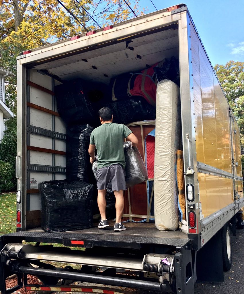 A man standing in a big moving truck full of packages
