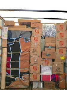 Moving truck loaded to the very top with packed moving boxes and supplies.