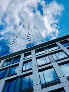 A modern, high-rise building and the sky with white clouds