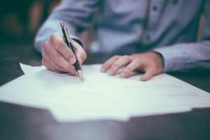 Man holding a pen, signing written moving quotes NJ