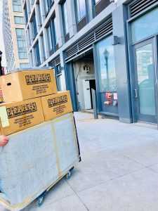 Moving boxes being delivered by movers Union NJ in front of a building