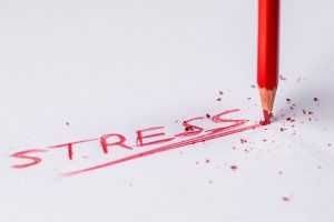 A pencil writing down the word stress.