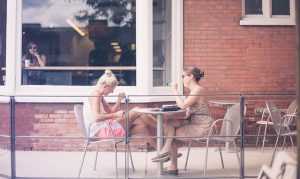 People who adjust as an expat in Essex county can spend time drinking coffee like these two women.