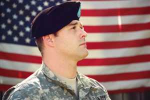 A member of the military and the US flag in the background