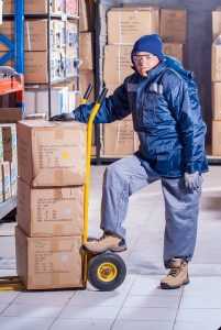 Mover with cardboard boxes on a dolly.
