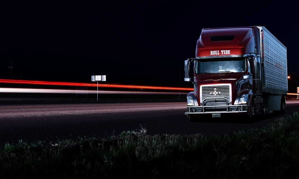 A red truck on a highway at night