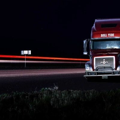 A red truck on a highway at night
