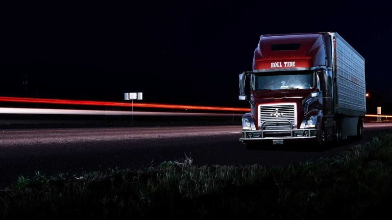 A red truck on a highway at night